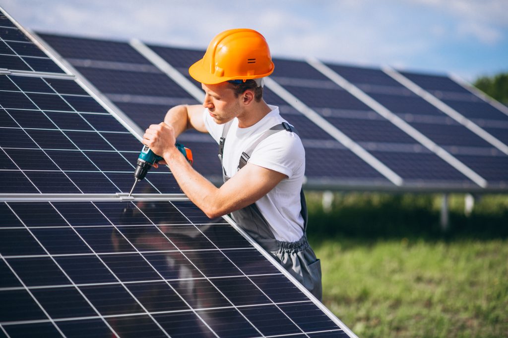 man worker in the firld by the solar panels